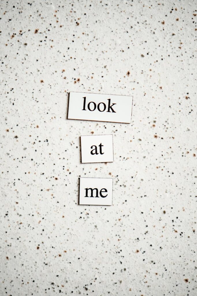 Minimalist text design with "look at me" on speckled surface, perfect for conceptual themes.